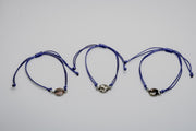 Three blue bracelets with lionfish charms on a light gray background