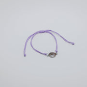 Purple bracelet with a lionfish charm on a light gray background