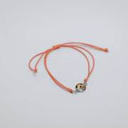 orange bracelet with a lionfish charm on a light gray background