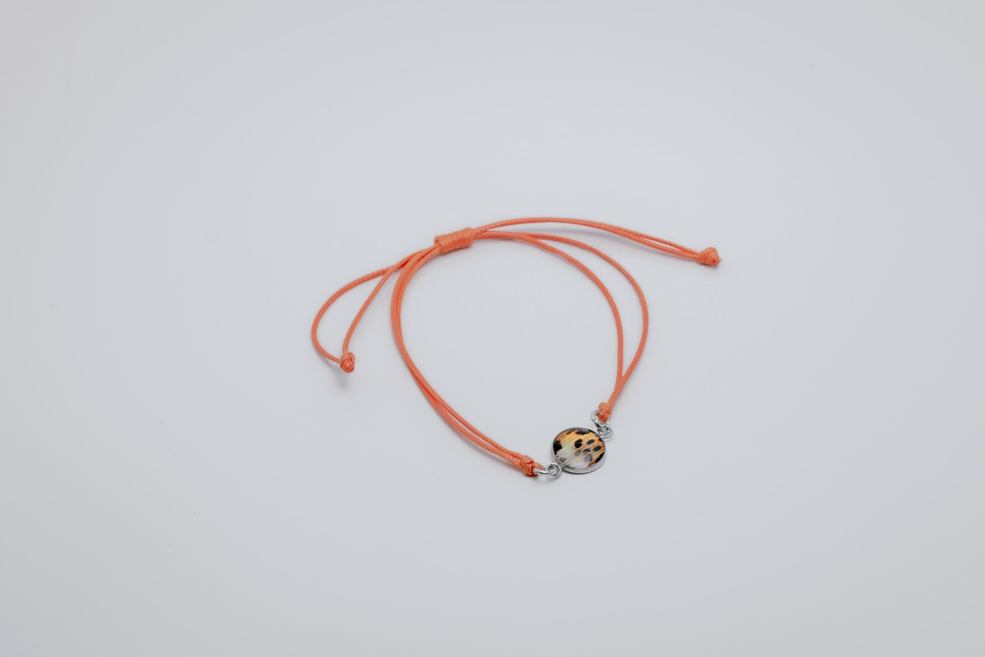 orange bracelet with a lionfish charm on a light gray background