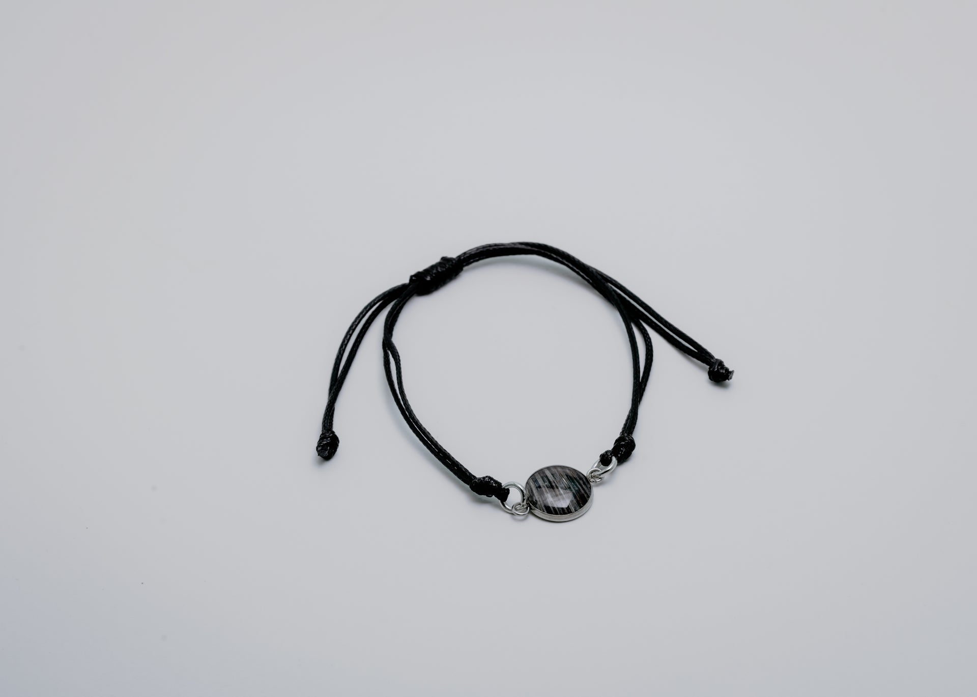 Black bracelet with a lionfish charm on a light gray background