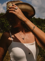 Person wearing a straw hat and white top in an outdoor setting