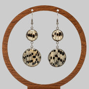 Dual Lionfish Silver Dangle earrings with tail fin pendants displayed on a circular wooden stand on a white background.  