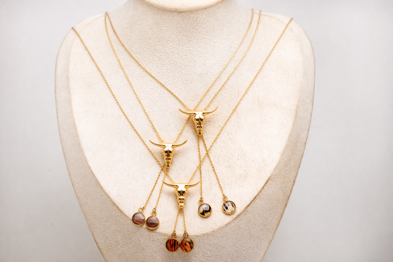 Set of gold necklaces with pendant lionfish fin drops on a mannequin bust.