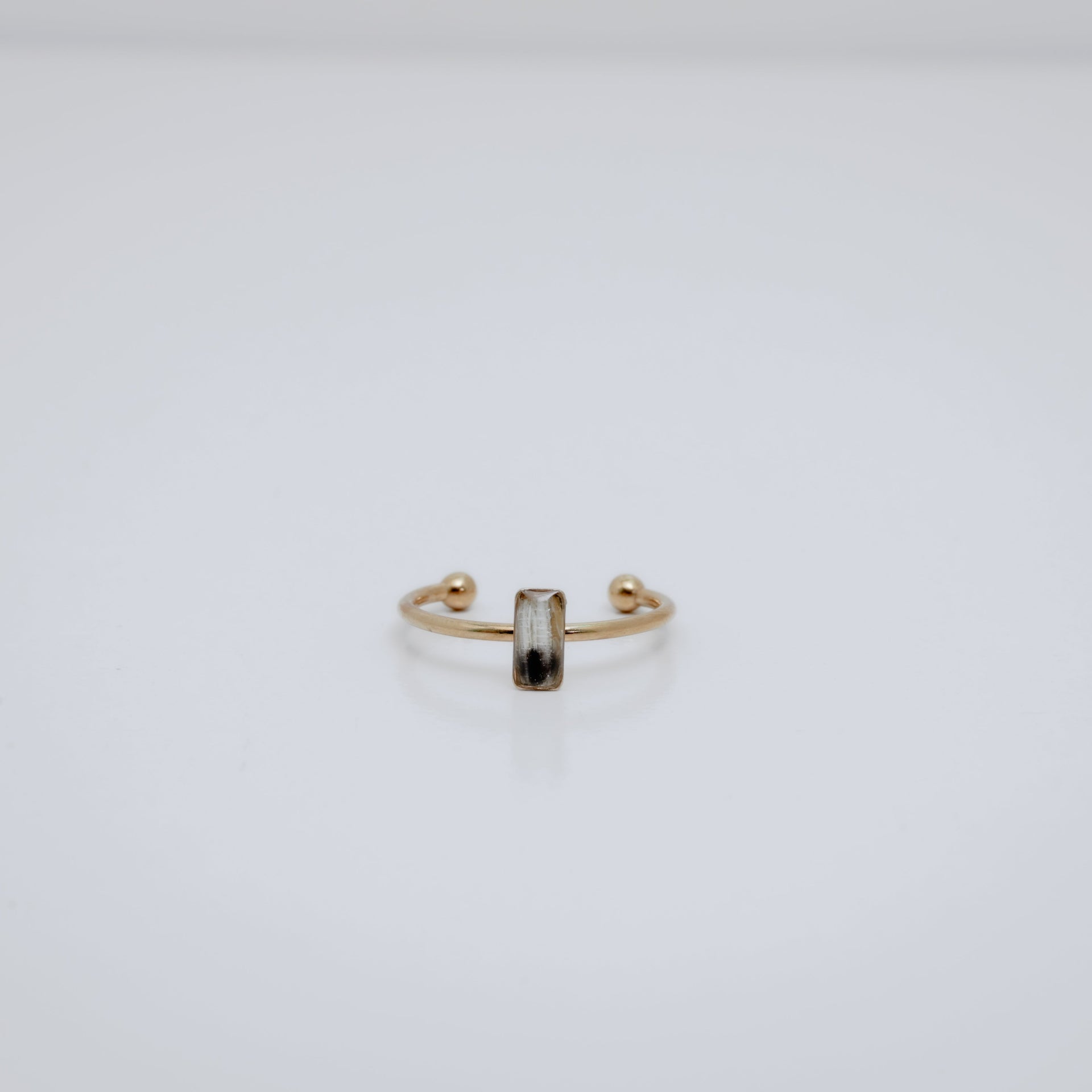 Gold ring with a small vertical bar on a white background
