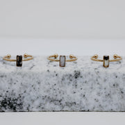 Three Gold rings with a small vertical bar on white and black marble on a white background