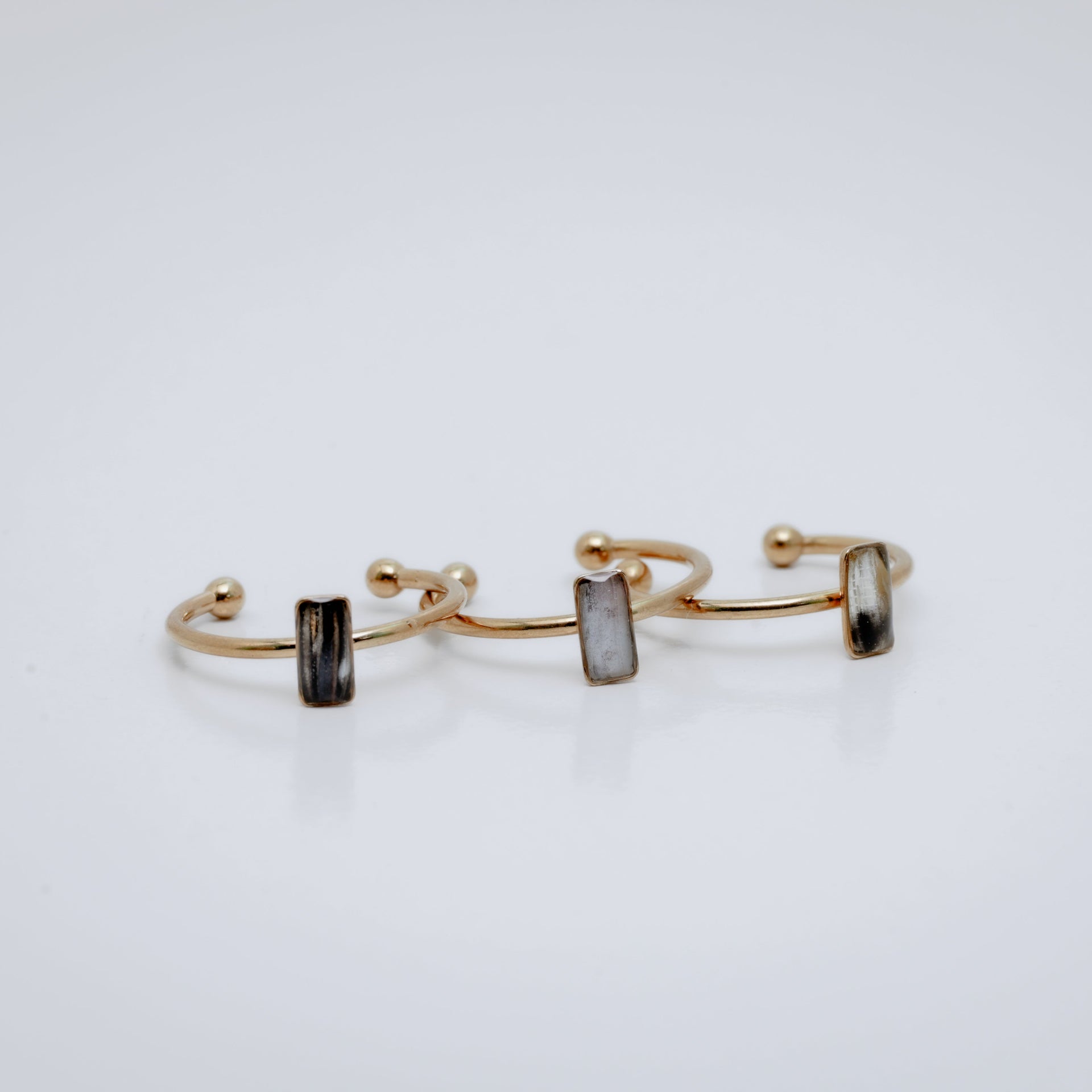 Three Gold rings with a small vertical bar on a white background