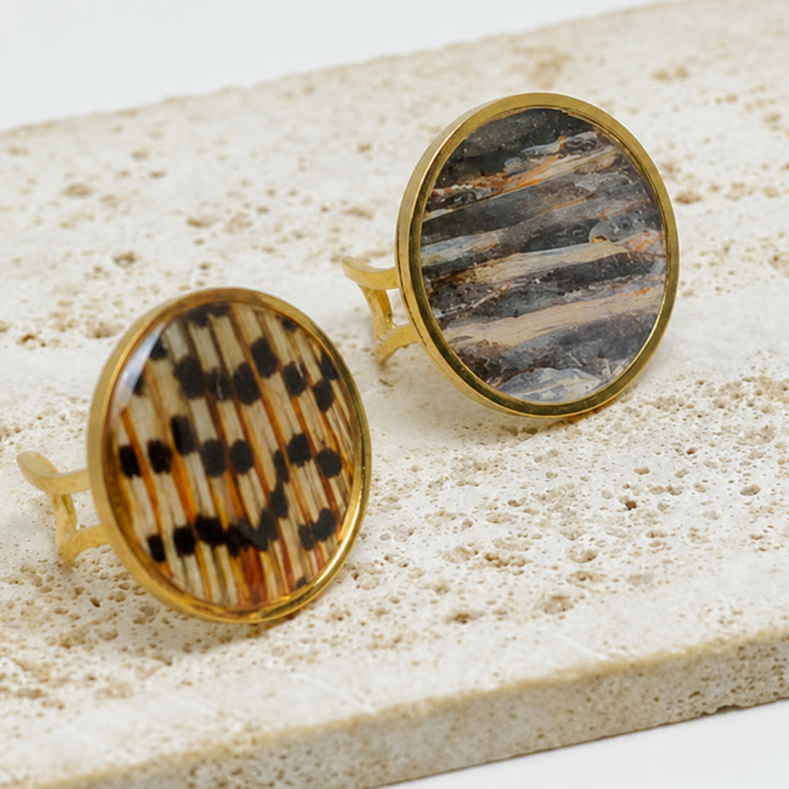 Gold statement ring with lionfish tail and pectoral fins on white marble.
