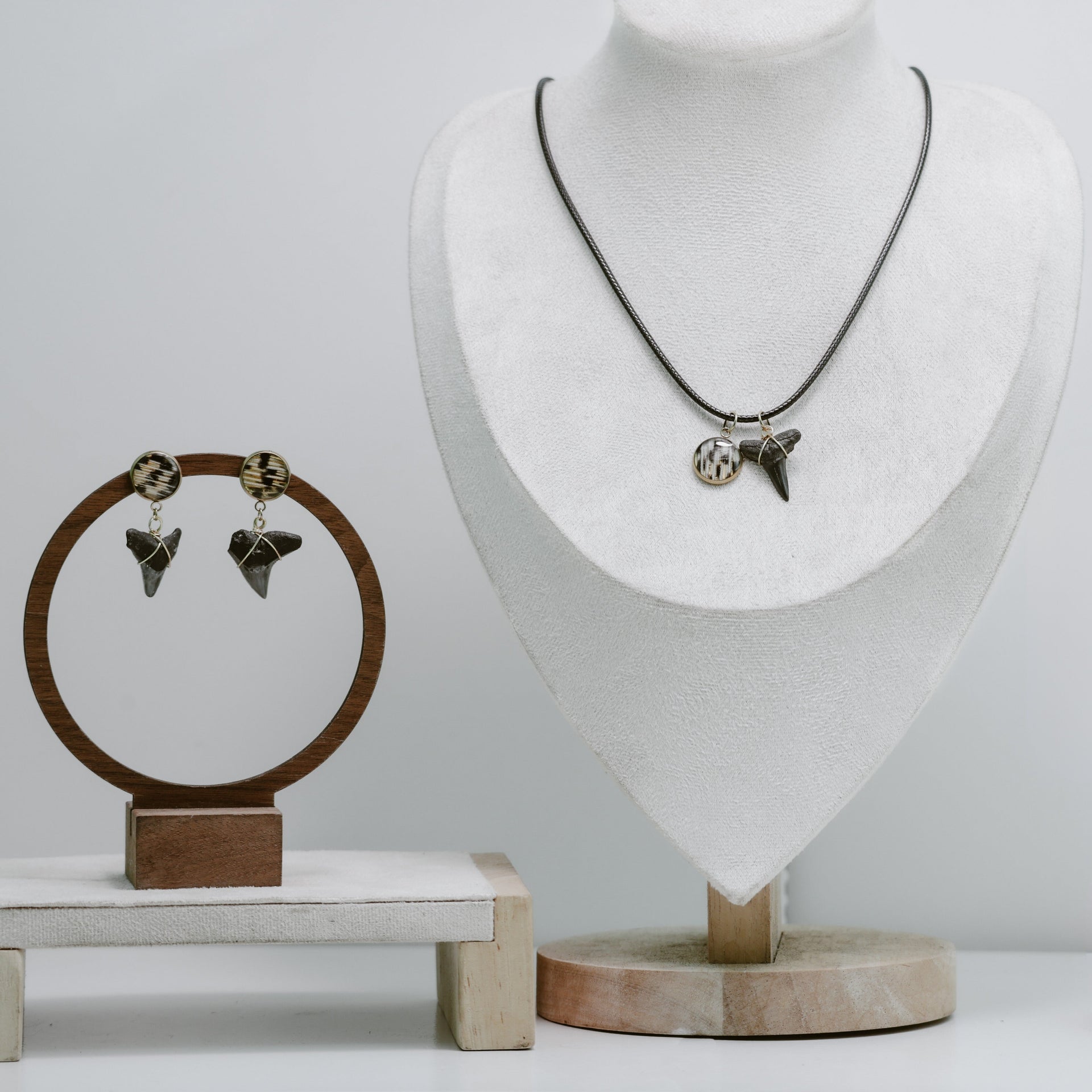 Jewelry set with earrings and a necklace on display stands against a white background