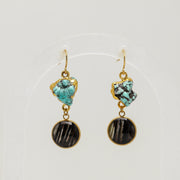 Pair of earrings with turquoise and black lionfish fins on a white background