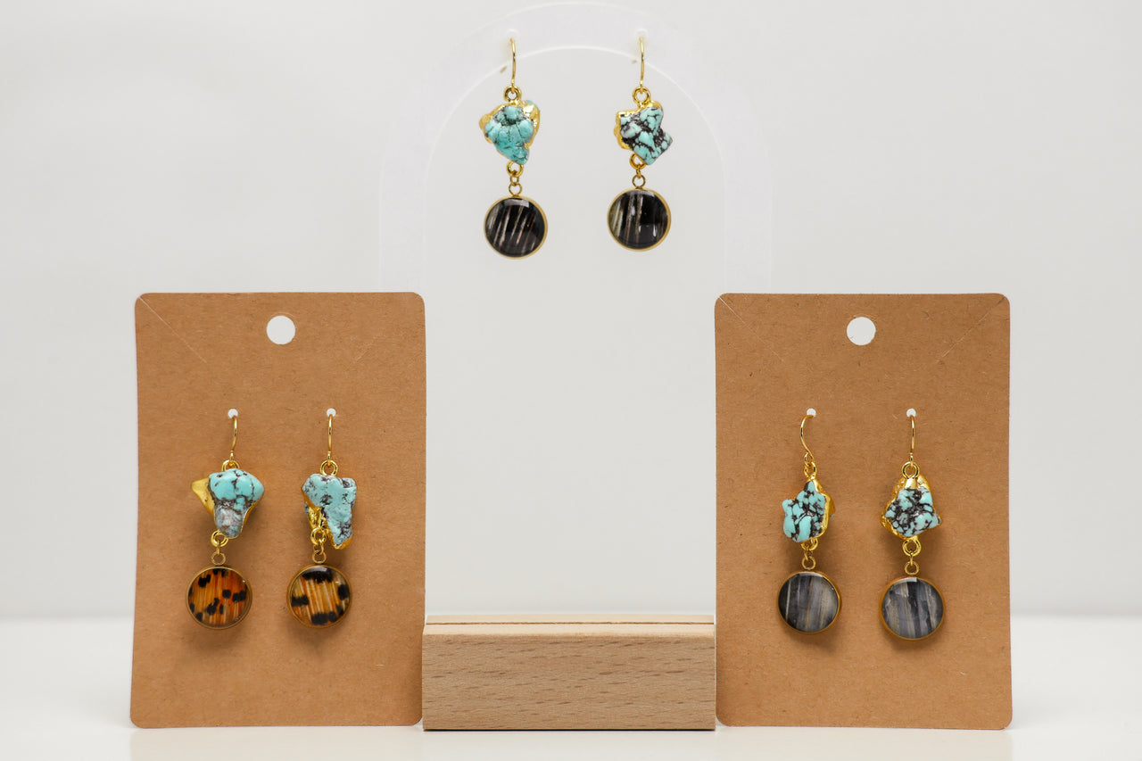 Pair of lionfish earrings on brown card holders against a white background