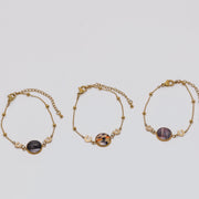 Three gold bracelets with lionfish fins on a light gray background