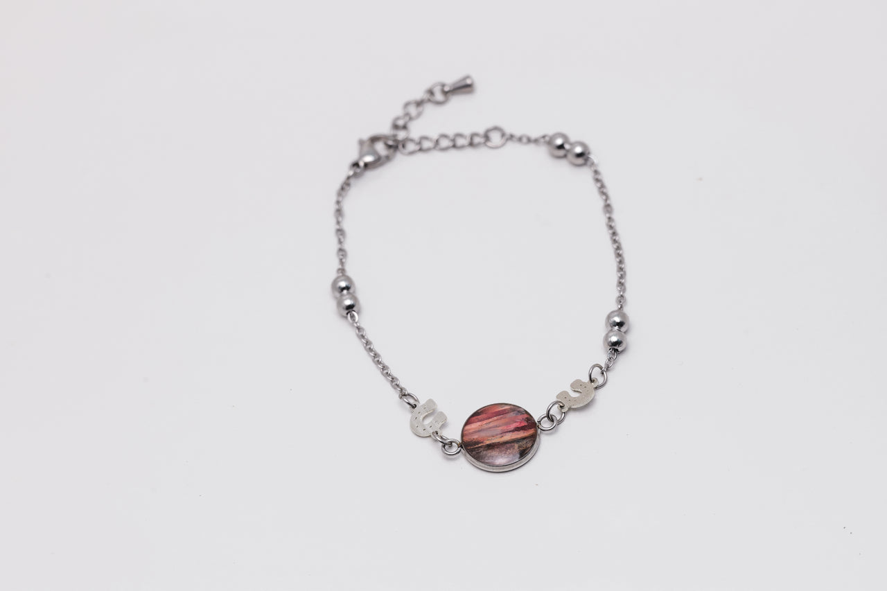 Silver bracelet with a pink lionfish fins on a white background