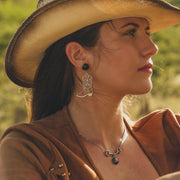 Woman wearing a cowboy hat with a blurred natural background