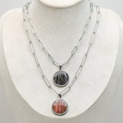 Two Large Silver Necklaces on a cream necklace display bust. 