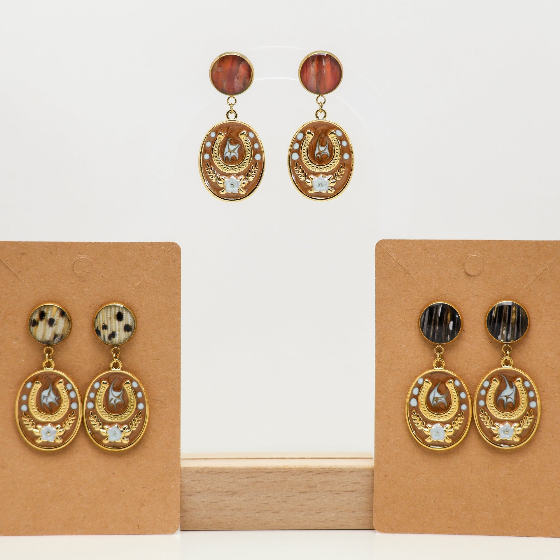 Pair of gold lionfish earrings on brown earring cards against a white background