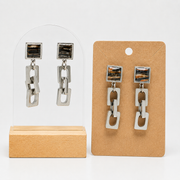 Two pairs of lionfish Chain Link Earrings on stands on a white background. 