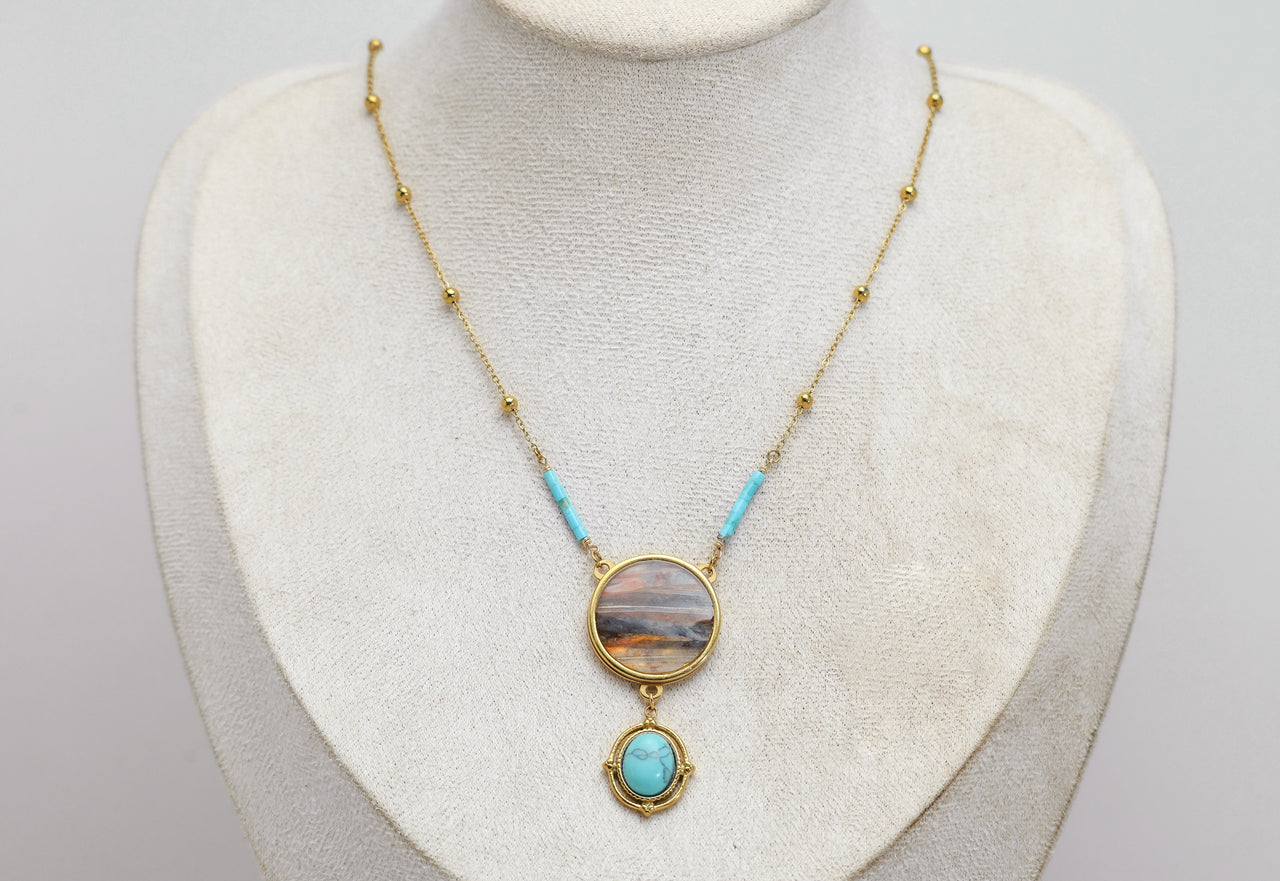 Necklace with a lionfish pendant and turquoise on a mannequin bust against a light background