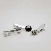 Three silver tie clips with lionfish fin button on a light gray background