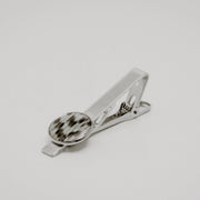 Silver tie clip with lionfish tail fin button on a light gray background