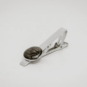 Silver tie clip with lionfish pelvic fin button on a light gray background