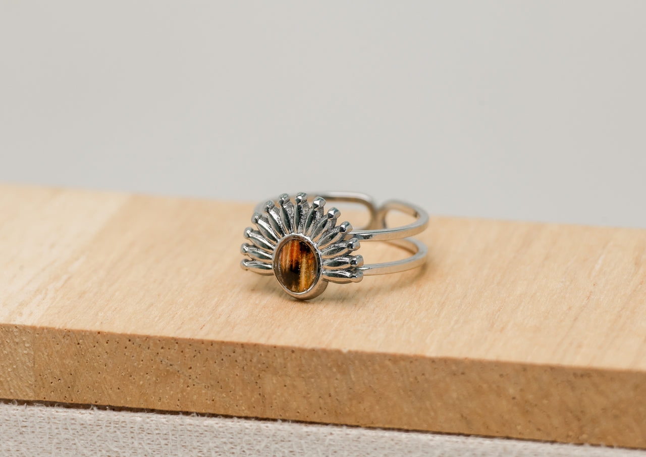 Silver ring with a lionfish fin on a wooden block