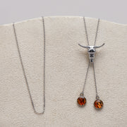 Necklace with pendant on a wooden stand against a gray background and lionfish fins