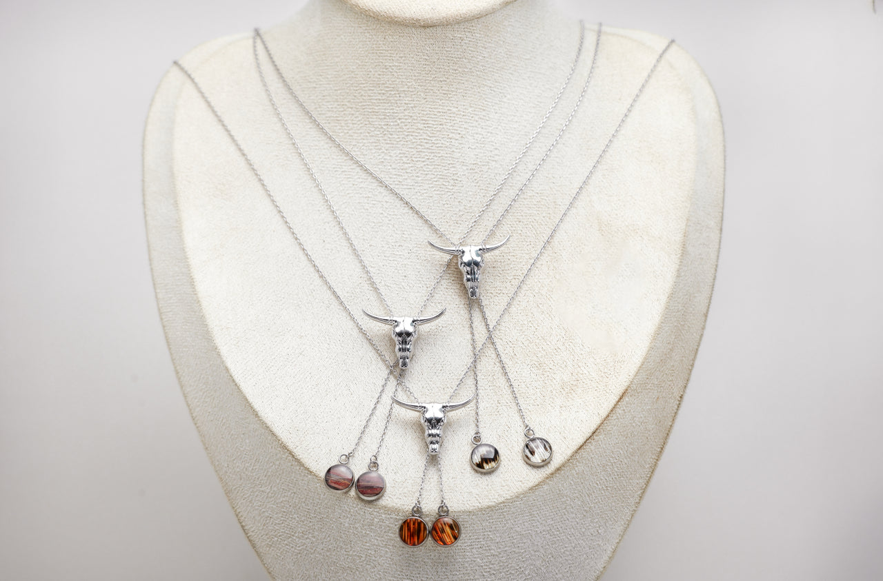 Set of silver necklaces with hanging lionfish pendants on a mannequin bust.