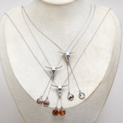 Set of silver necklaces with hanging lionfish pendants on a mannequin bust.