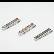 Three silver tie clips with lionfish inlay on a white background