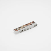 Silver tie clip with lionfish tail fin inlay on a white background