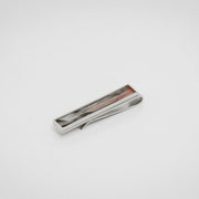 Silver tie clip with lionfish pectoral fin inlay on a white background