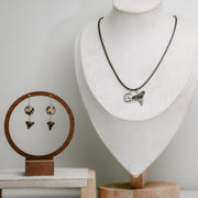 Jewelry set including a necklace and earrings displayed on mannequin and wooden stands.