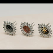 Three silver rings with lionfish fins on a beige surface