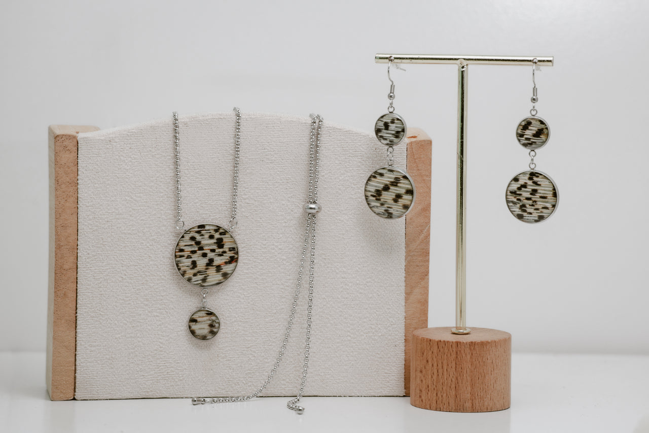 Silver jewelry set with necklace and earrings on a white background