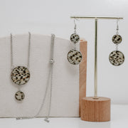 Silver jewelry set with necklace and earrings on a white background