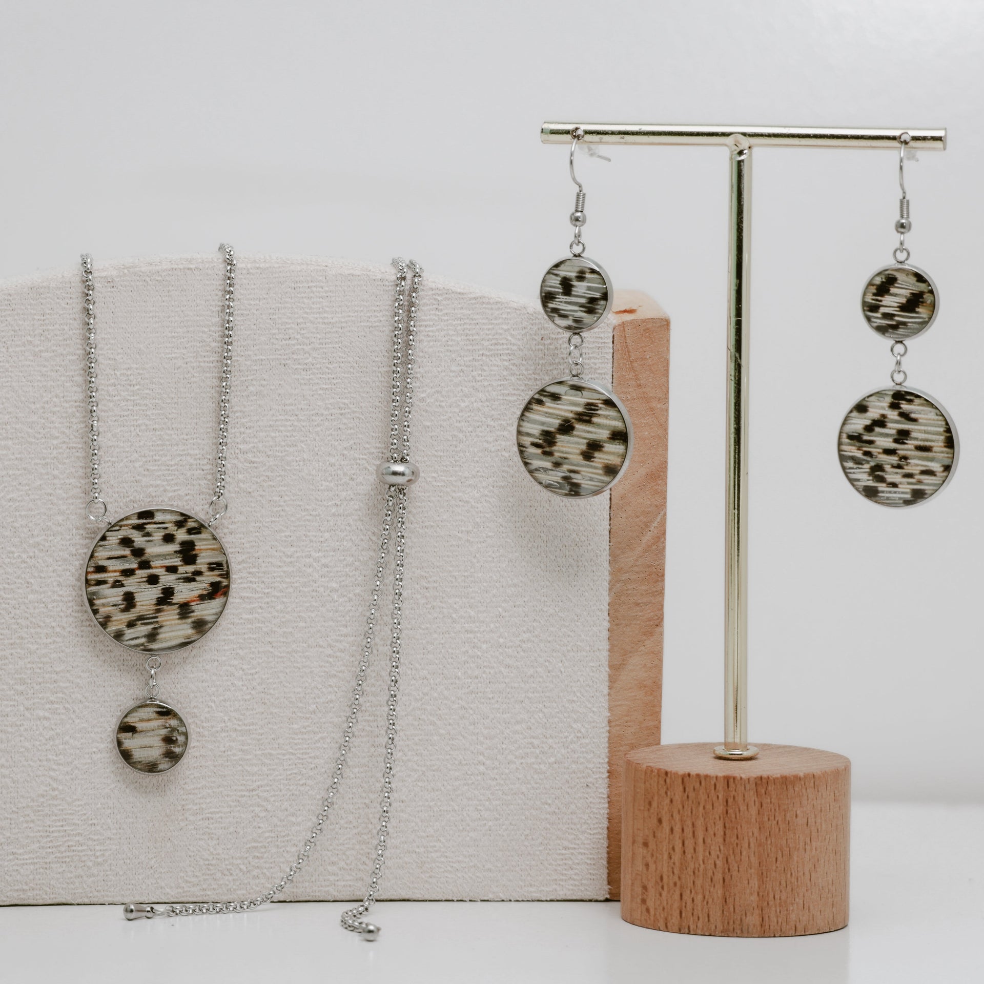 Silver jewelry set with necklace and earrings on a white background