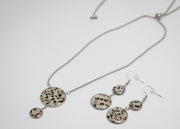 Silver Jewelry set with necklace and earrings featuring circular patterns on a white background