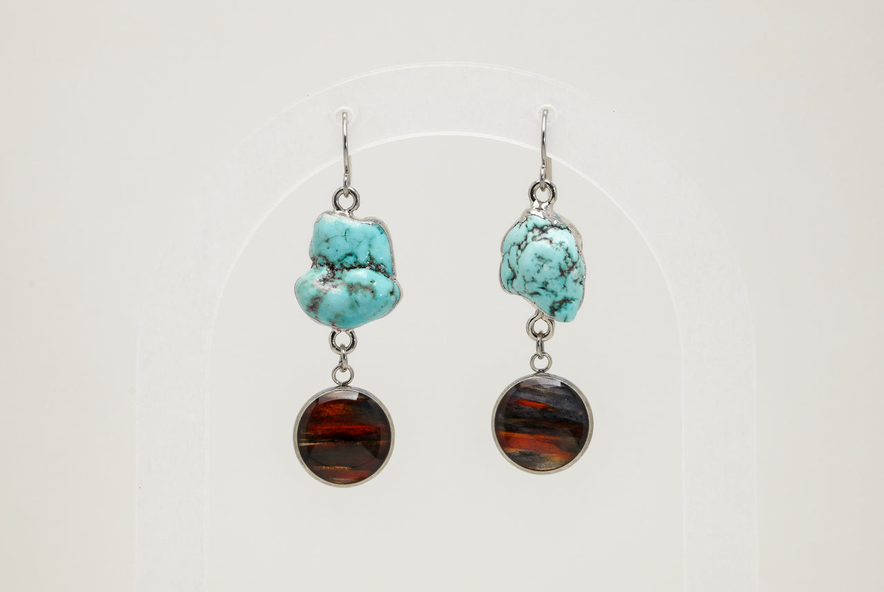 Turquoise and lionfish earrings on a white background