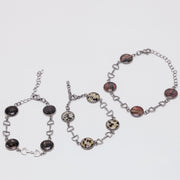 Three bracelets with dark lionfish fins on a white background