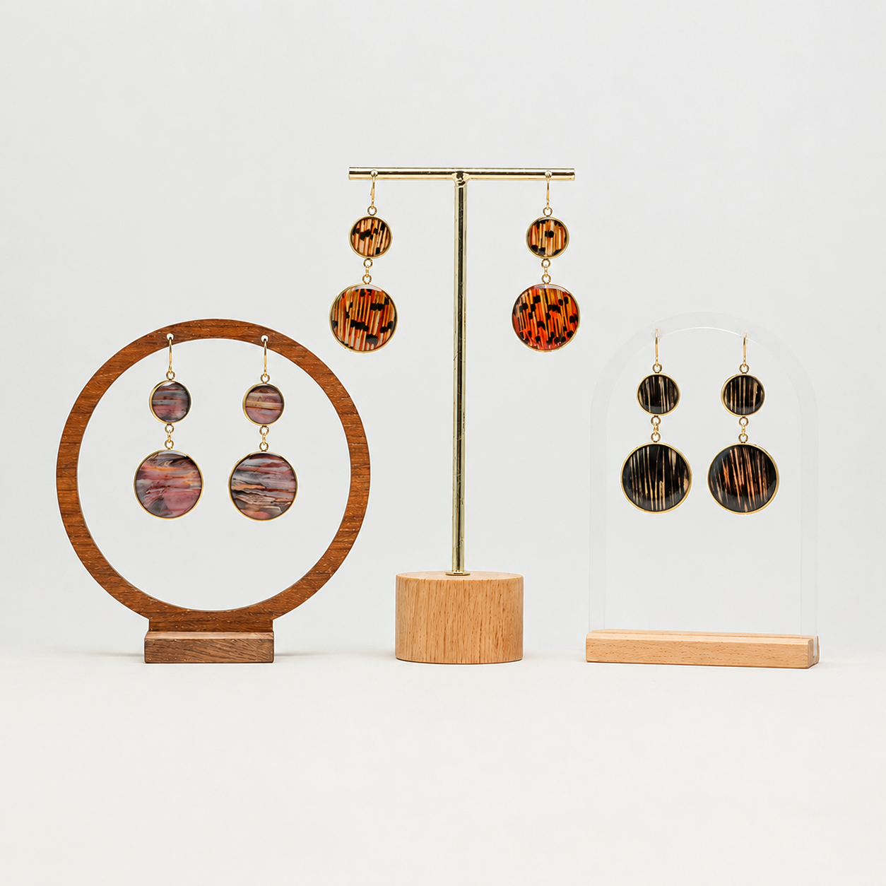 Gold stainless steel dangle earrings with lionfish fins in resin on display stand