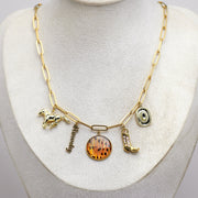 Gold necklace with western and lionfish charms on a white mannequin bust