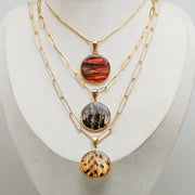 Three X-Large Gold Necklaces on a cream necklace display bust. 