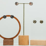 Three pairs of Large Studs on stands on a white background. 