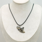 A Shark Tooth Necklace on a cream necklace display bust. 