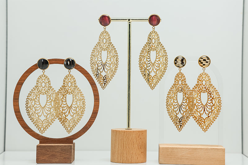 Three pairs of Golden Hour Lace Earrings on stands on a white background.  