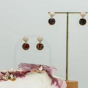 Two pairs of Faux Mini Scallop Earrings on a white background. A third pair sits inside a pink clam shell at the bottom of the image. 