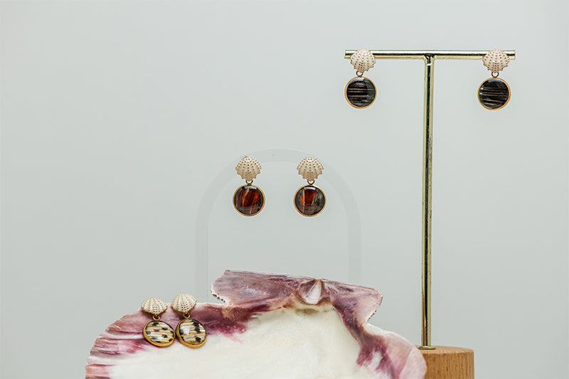 Two pairs of Faux Mini Scallop Earrings on a white background. A third pair sits inside a pink clam shell at the bottom of the image. 