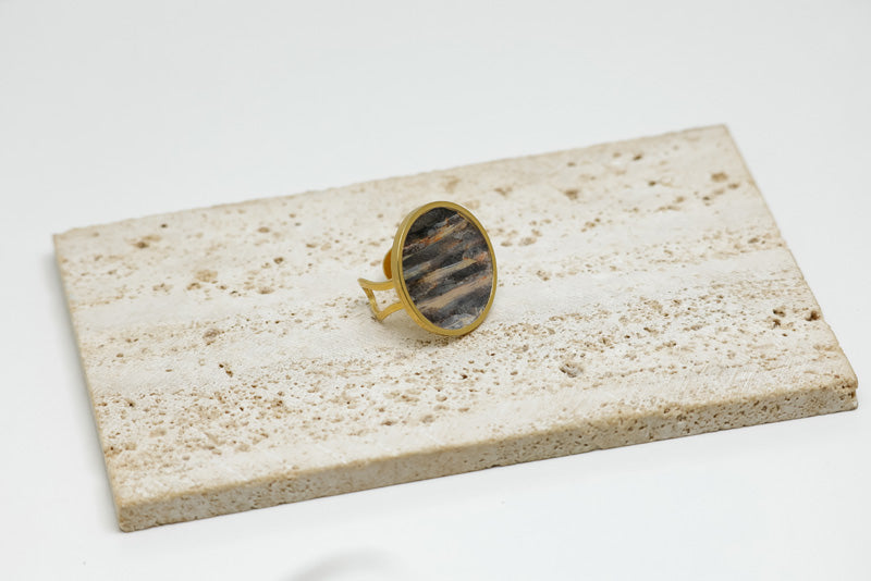 A Gold Statement Ring on white marble on a white background.