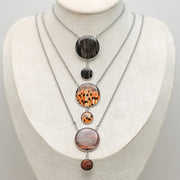 Three Adjustable Statement Necklaces on a cream necklace display bust. 